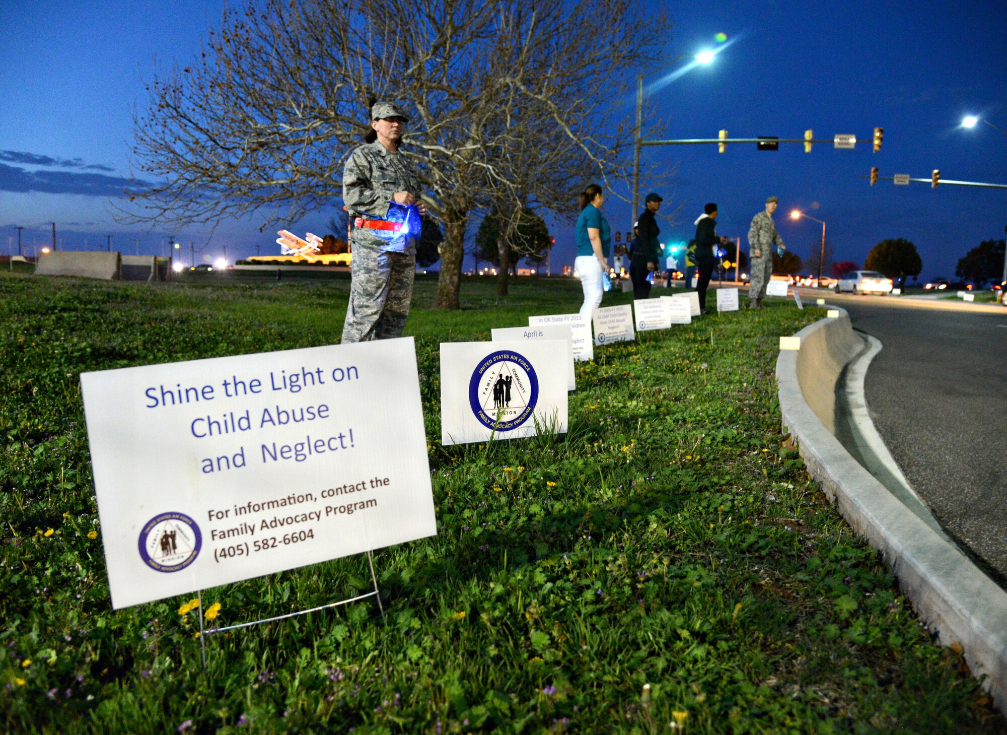 Maj. Dana Tanner, 72nd Medical Operations Squadron, along with other members of the 72nd Air Base Wing and the Sexual Assault Prevention and Response Office, joined together to promote Family Advocacy’s theme for Child Abuse Prevention Month, “Shine the Light on Child Abuse,” by holding lit luminarias inside the Air Depot Gate as people arrived for their workdays. The volunteers also hung teal ribbons in the trees around base, symbolizing SAPR month. (Air Force photo by Kelly White)