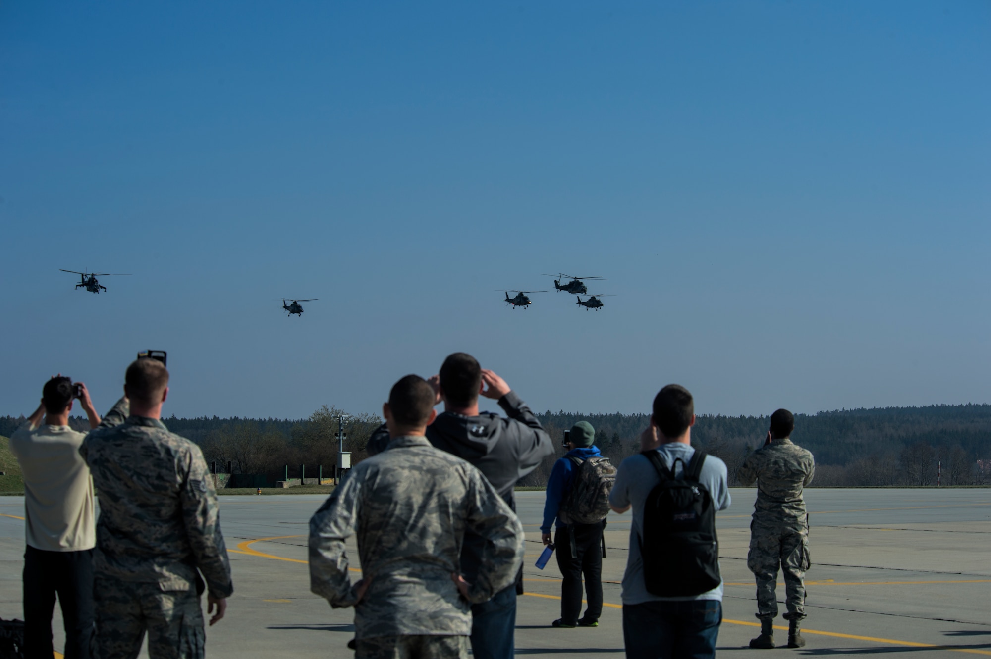 U.S. Air Force Airmen assigned to the 354th Expeditionary fighter Squadron watch as an assortment of Czech Republic air force helicopters fly in formation in a show of force during a theater security package deployment to Namest Air Base, Czech Republic, April 9, 2015. These deployments aim to send a clear message to the international community that the U.S. is serious about security and stability in the region. (U.S. Air Force photo by Staff Sgt. Christopher Ruano/Released)