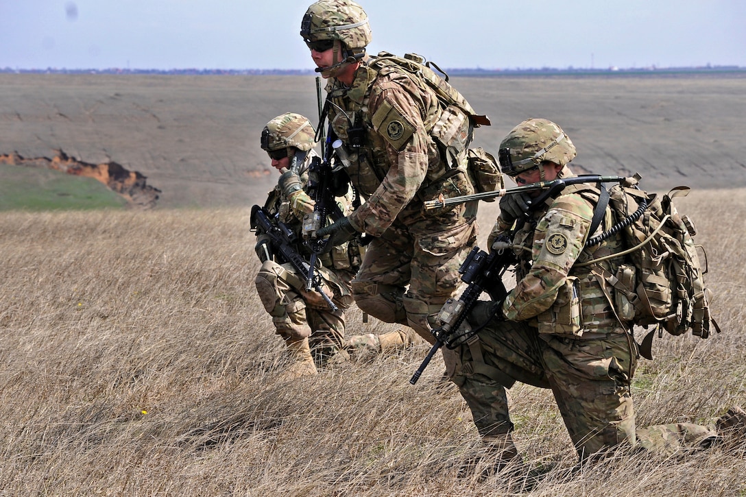 Left to right: U.S. Army Spc. Simon Saliba, 1st Lt. David A. Poole and Sgt. Timothy Dehaas move toward their objective during a live-fire exercise in Romania, April 8, 2015. Saliba, a radio operator, Poole, a platoon leader, and Dehaas, a forward observer, are assigned to the 2nd Cavalry Regiment.
