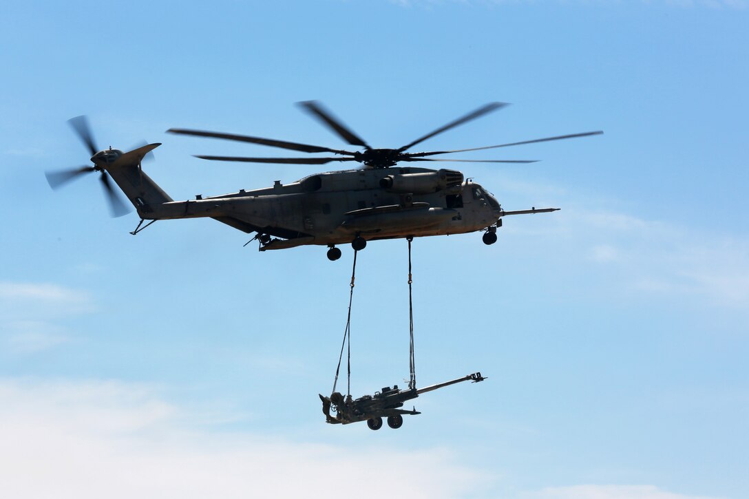 A Marine Corps CH-53E Super Stallion helicopter slingloads a M777 ...