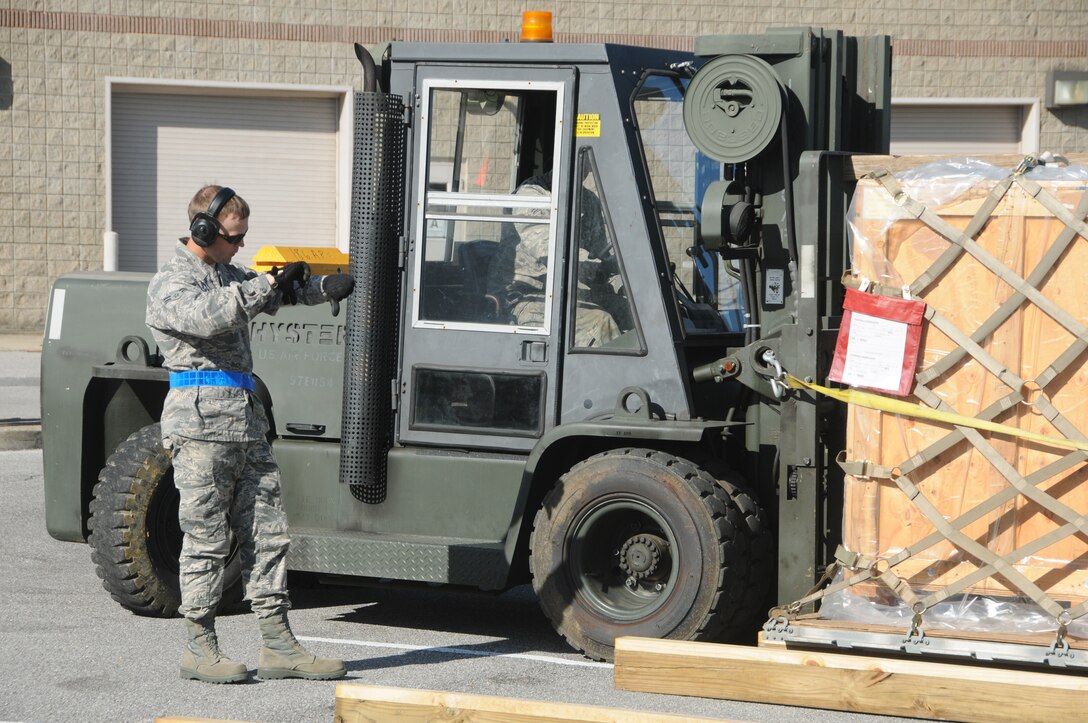 U. S. Air Force Airman 1st Class Adam Dyess, with the 186th Logistics Readiness Squadron, signals directions to a fork lift operator on Key Field Air National Guard Base, Meridian, Miss., April 11, 2015.  During an alert mobility exercise, Key Field personnel executed their rapid response plan to forward deploy more than 200 airmen. (U. S. Air Force Photo by Tech. Sgt. Richard L. Smith/Released)