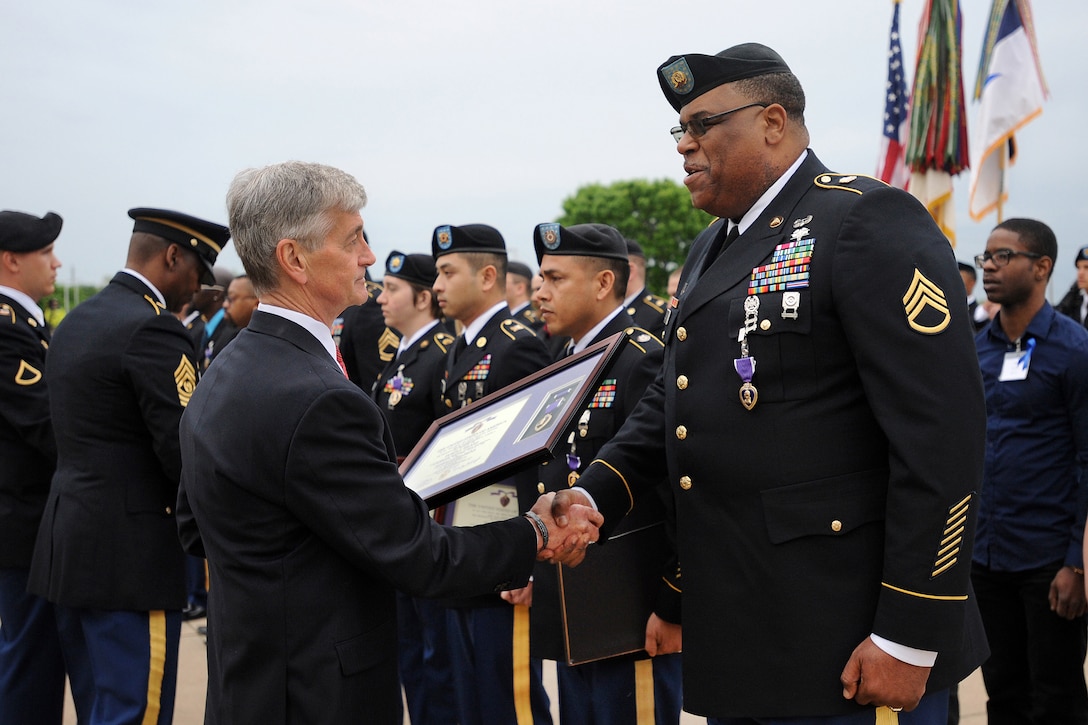 Army Secretary John M. McHugh presents the Purple Heart to Army Staff Sgt. Alonzo Lunsford Jr. during the Purple Heart and Defense of Freedom award ceremony on Fort Hood, Texas, April 10, 2015.