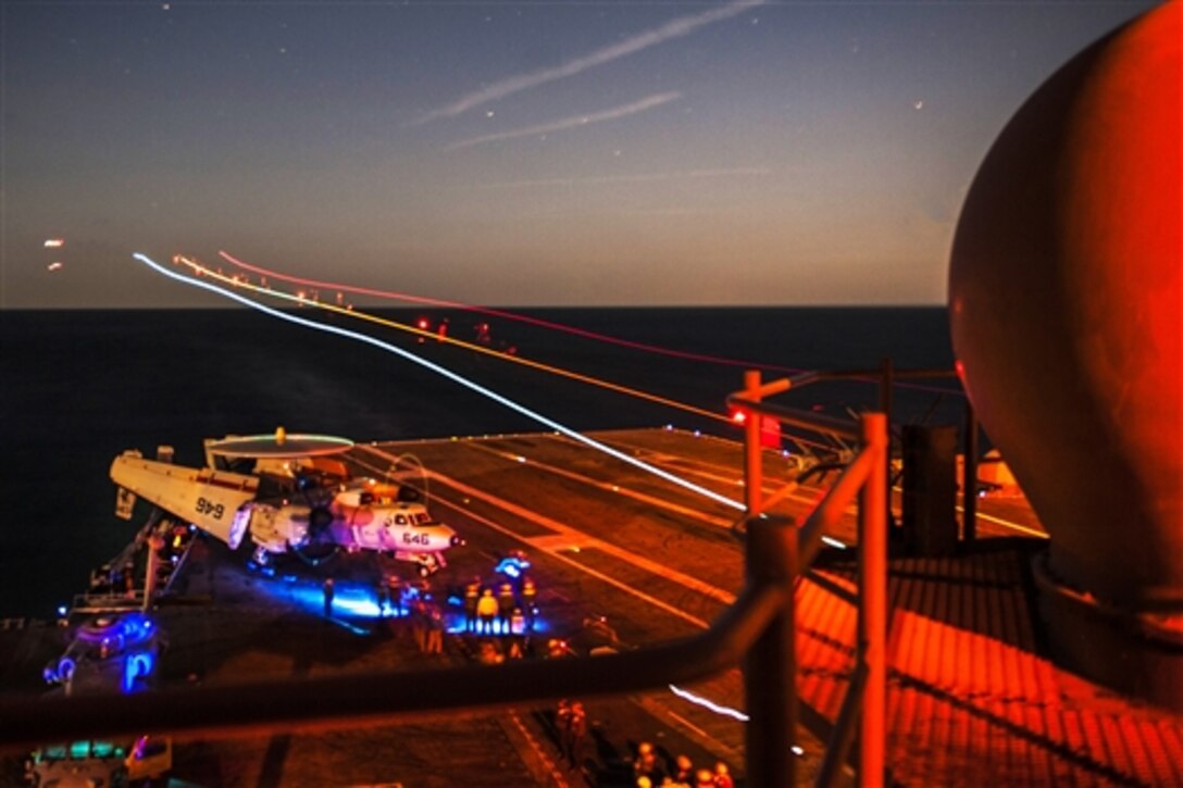An E-2C Hawkeye lands on the flight deck of the aircraft carrier USS George H.W. Bush during night  flight operations in the Atlantic Ocean, April 4, 2015. The carrier is conducting training exercises in the Atlantic Ocean. The Hawkeye is assigned to Carrier Airborne Early Warning Squadron 120. 