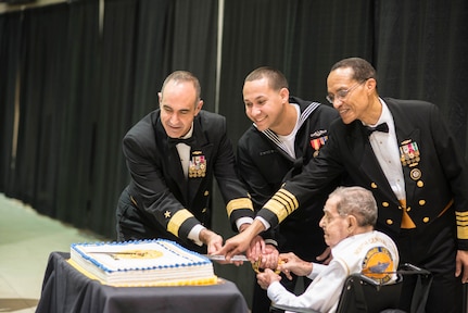 U.S. Navy Adm. Cecil D. Haney (standing right), U.S. Strategic Command commander, U.S. Navy Rear Adm. Charles "Chas" Richard (left), Submarine Group 10 commander, U.S. Navy Seaman Louis Velasquez Perez (center), a fire control technician aboard the USS Georgia (SSGN 729) (Gold), and Ed Schuele, a submarine veteran, cut the ceremonial cake during the 115th U.S. Submarine Service Birthday Ball, Kings Bay, Ga., Apr. 11, 2015. As a submariner himself, Haney gave the keynote speech during the ceremony, which celebrated the achievements of submarine forces across the U.S. fleet. Submarine Group 10 operates both guided missile and ballistic missile submarines, the latter of which comprise the most survivable leg of the nation's nuclear triad, which also includes intercontinental ballistic missiles and strategic bombers. In keeping with military tradition, the most junior service member in attendance, Perez, who was officially qualified by Haney just prior to the photo, and the most experienced, Schuele, who was qualified in 1946, joined the two commanders in the ceremonial cutting of the cake. (U.S. Navy photo by Machinist's Mate Petty Officer 1st Class Andrew Pigg)