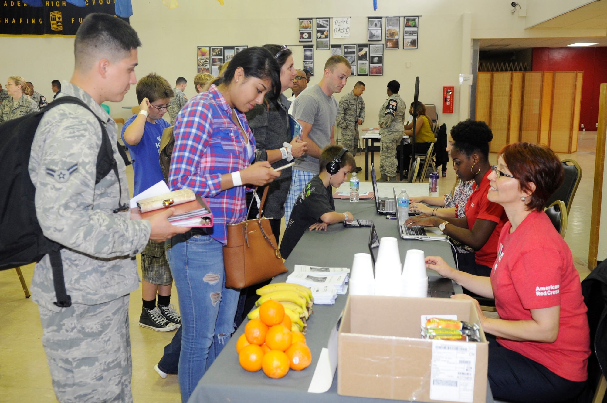 Volunteers answer questions the Non-combatant Evacuation Operation volunteers have during a NEO exercise on Kadena Air Base, Japan, April 8, 2015. This NEO exercise was set up by the Airman and Family Readiness Center to help dependants and other non-combatants understand the evacuation process in the event of an emergency that would make it unsafe for them to remain on island. (U.S. Air Force photo by Staff Sgt. Marcus Morris)