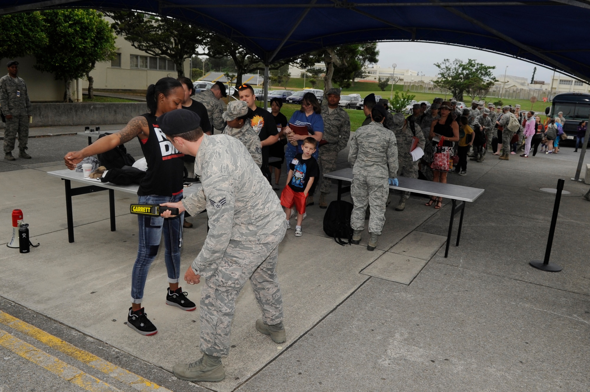 U.S. Air Force 18th Security Forces Squadron response force members inspect Non-combatant Evacuation Operation volunteers and their baggage at a security check point during an exercise on Kadena Air Base, Japan, April 8, 2015. Non-combatants are evacuated from the island to a safe location in the event of an emergency such as a severe typhoon. NEO exercises are intended to test efficiency and what changes may need to be made. (U.S. Air Force photo by Staff Sgt. Marcus Morris)