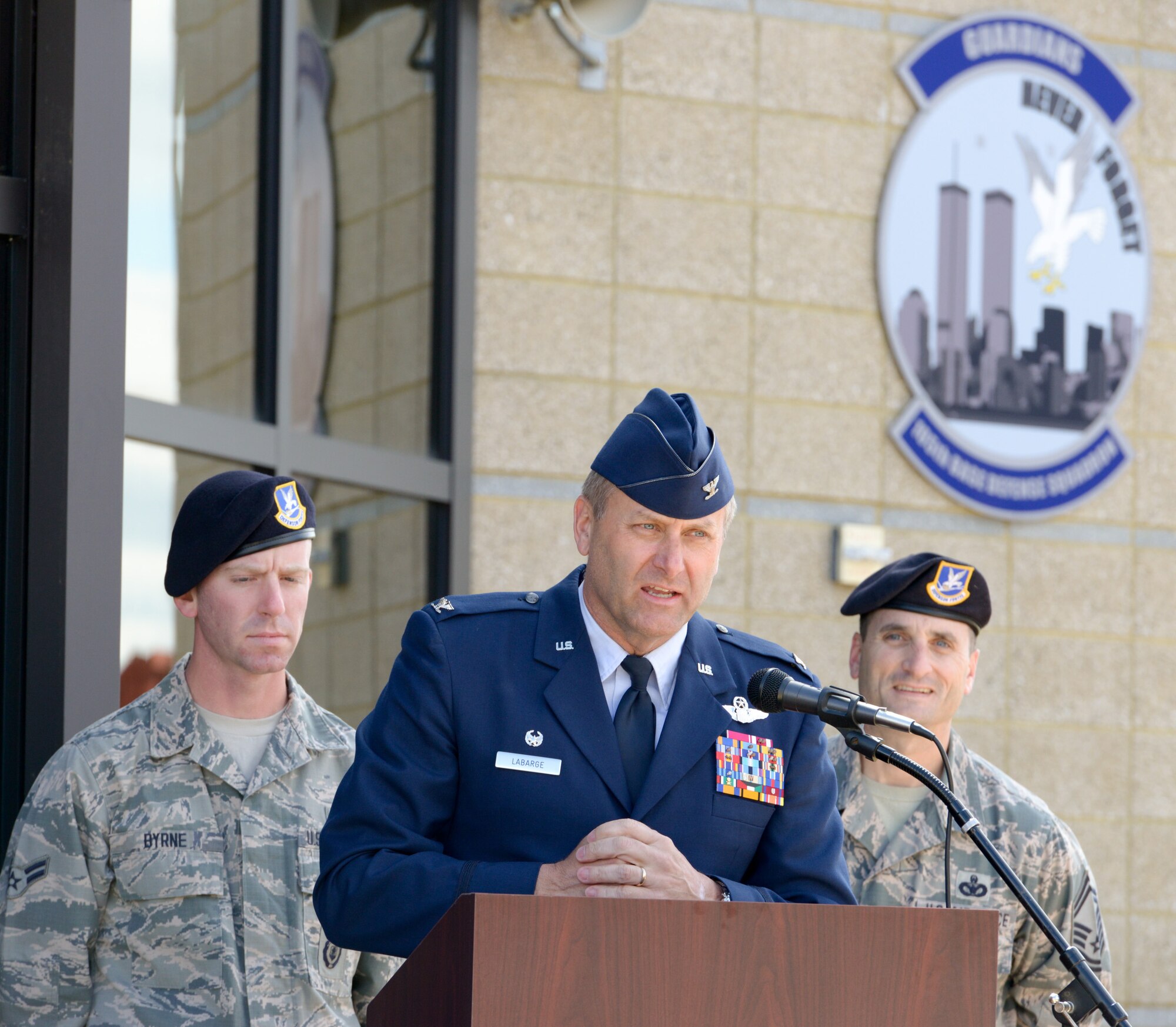 U.S. Air Force Col Timothy J. LaBarge, commander of the 105th Airlift Wing, New York Air National Guard, addresses guests, media and members of the military community of Stewart Air National Guard base at a ribbon cutting event to officially open the Wing's Base Defense Squadron Headquarters building. The opening was held shortly after the posthumous award of the Bronze Star Medal with Valor to SSgt. Todd "T.J." Lobraico on April 11, 2015. Lobraico Jr., a member of the 105th Airlift Wing, was killed in action in Afghanistan on Sept. 5, 2013, (U.S. Air National Guard photo by SSgt Michael OHalloran/Released) 