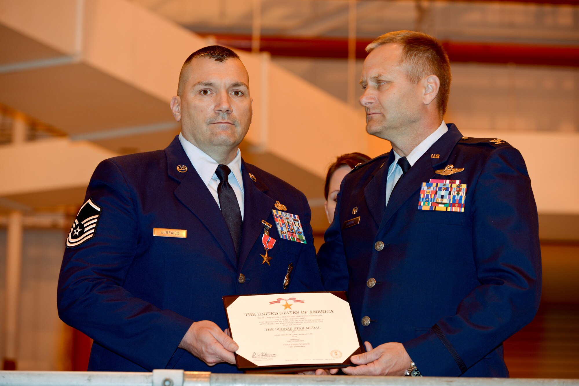 U.S. Air Force  Master Sgt. Todd Lobraico and Col Timothy J. LaBarge, commander of the 105th Airlift Wing, New York Air National Guard, show the posthumous award of the Bronze Star Medal with Valor to his son SSgt. Todd "T.J." Lobraico, during a ceremony at Stewart Air National Guard Base on April 11, 2015. Lobraico Jr., a member of the 105th Airlift Wing, was killed in action in Afghanistan on Sept. 5, 2013, (U.S. Air National Guard photo by SSgt Michael OHalloran/Released) 