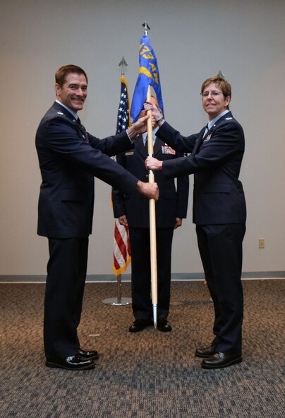 Col. William W. Whittenberger Jr., 433rd Airlift Wing commander, presents the 433rd Maintenance Group guidon to Col. Gretchen M. Wiltse, 433rd MXG commander, during the group assumption of command ceremony April 12, 2015 at the Inter-American Forces Academy auditorium on Joint Base San Antonio-Lackland. Wiltse comes to the 433rd MXG from Dover Air Force Base, Delaware, where she served as the 512th Mission Support Group commander. (U.S. Air Force photo/Tech. Sgt. Lindsey Maurice)