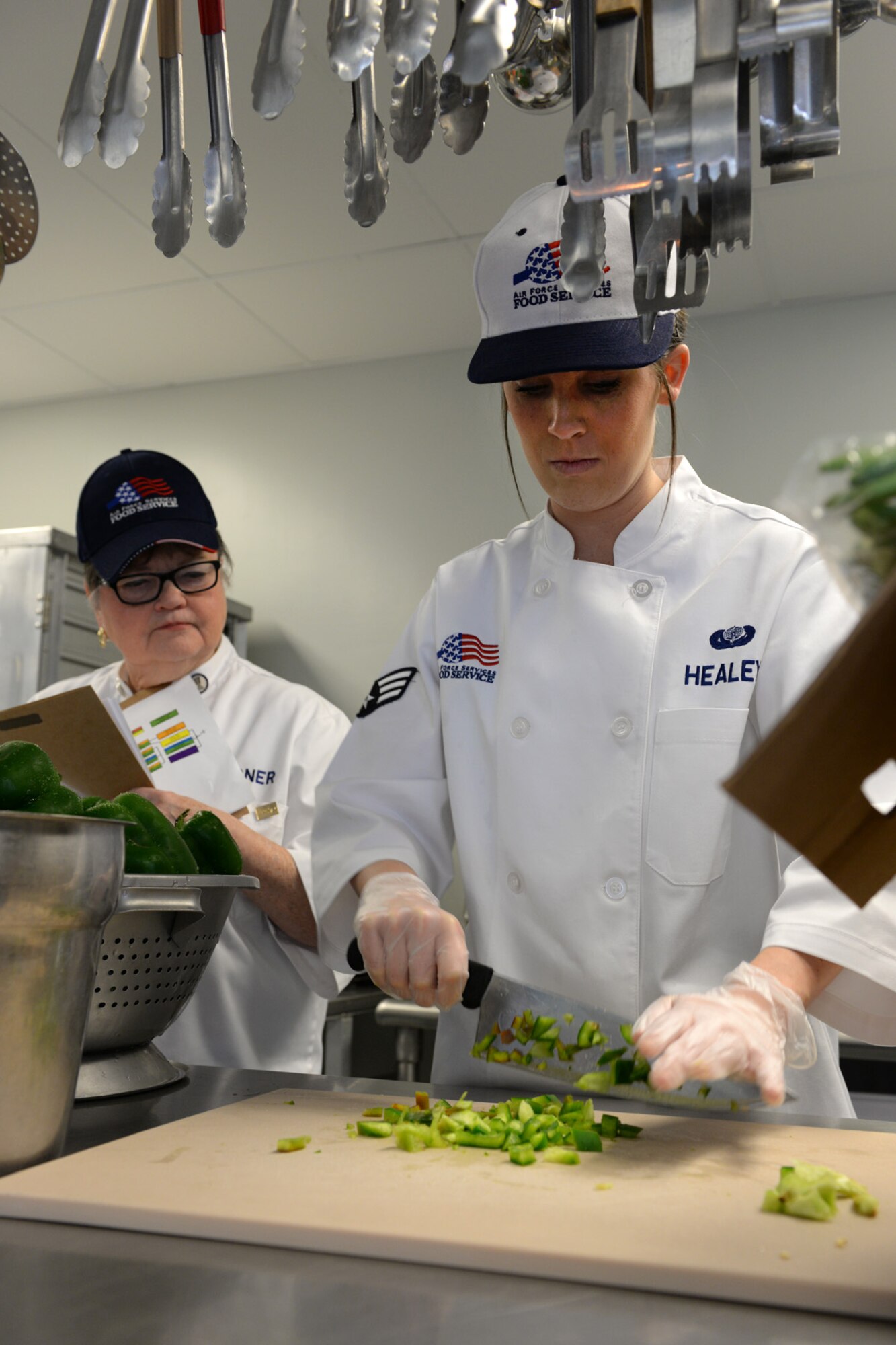 Senior Airman Nicki-Anne Healey, 157th Force Support Squadron Services Flight technician, prepares a meal under the watchful eye of a Senior Master Sergeant Kenneth Disney Award inspection team member in the Aerospace Dining Facility April 11. The 157 FSS team has been selected as one of the top three Air National Guard food services operations in the nation. Entering its 15th year, the Disney Award has been established to improve food service throughout the Air National Guard, increase morale, encourage competition, recognize excellence and honor the late Disney. Disney was the services superintendent at McGee Tyson Air Base, Tenn., for more than 20-years where he earned a reputation for commitment to providing outstanding food service. (N.H. Air National Guard photo by Senior Airman Kayla McWalter)
