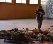 A active shooter, portrayed by an exercise staff member, enters Building 1216 at the Kelly Field Annex at Port San Antonio on April 11, 2015 and orders the exercise participants to the ground. Over 60 Alamo Wing members participated in the scenario. (U.S. Air Force photo by Tech Sgt. Carlos J. Trevino)
