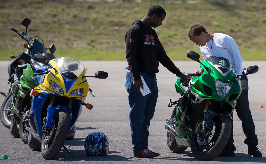 Spc. Tyrone Neal (left) and Staff Sgt. Danielle Stansell, 7th Special Forces Group, inspect a motorcycle during the training course April 1 at Duke Field, Fla.  Members from the 919th Special Operations Wing and the 7th Special Forces Group completed the Special Operations Command safety-hosted rider coach preparatory course to become state endorsed safety course instructors.  (U.S. Air Force photo/Tech. Sgt. Jasmin Taylor)