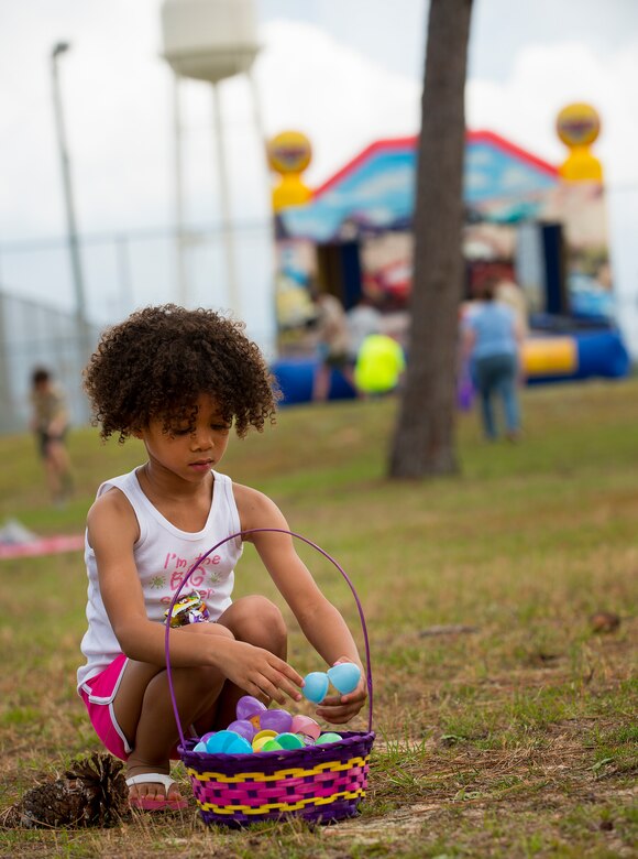 A Duke Field dependent looks through her basket during the spring 5k run and egg hunt April 11 at Duke Field, Fla. More than 50 people participated in the free event hosted by the Human Resource Development Council to boost base morale.  An Easter egg hunt followed the 5k at the playground with a bouncy house. (U.S. Air Force photo/Tech. Sgt. Jasmin Taylor)