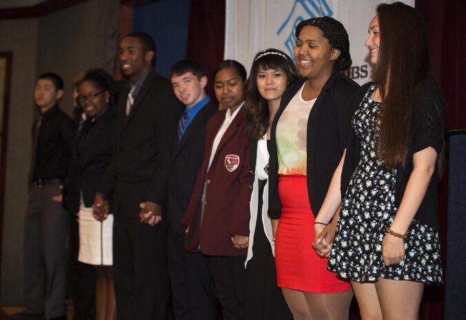 The nine teens competing in the 2015 Youth of the Year competition for Asia stand together waiting for the announcement of the winner at the Sakura Theater aboard Marine Corps Air Station Iwakuni, Japan, April 10. The BGCA organized the Youth of the Year competition every year since 1947, recognizing the extraordinary achievements of teens involved in their programs.