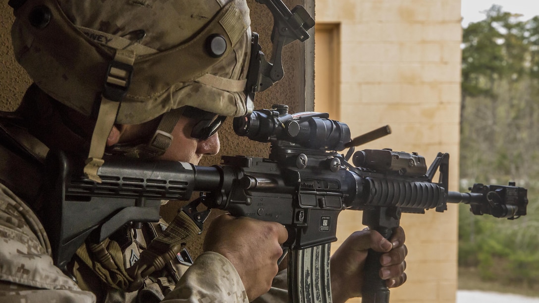 Corporal Ryan Harney, a team leader with 2nd Combat Engineer Battalion, 2nd Marine Division, and St. Charles, Mo. native, fires at an oppositional force member in the offense during Military Operations in Urban Terrain, or MOUT, training aboard Camp Lejeune, North Carolina, April 8, 2015. The training included Marines going out in squad-sized elements to attack an objective being held by Marines in the defensive position after the squad leaders built terrain models and informed their Marines on avenues of approach and objectives. (U.S. Marine Corps photo by Cpl. Krista James/Released)