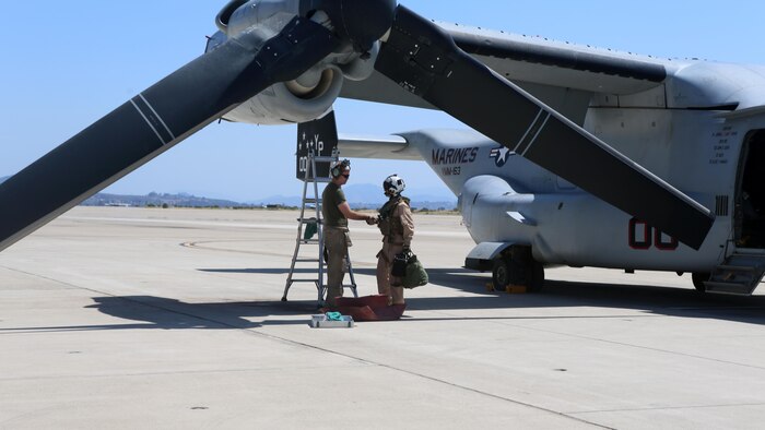 Lt. Col. Jason Holden, right, commanding officer of Marine Medium Tiltrotor Squadron 163, and a Woodbridge, Virginia native, shakes the hand of Cpl. Andrew Sturgess, his crew chief and a Sidney, Indiana, native, after a successful training flight aboard Marine Corps Air Station Miramar, California, April 10. This training operation marks the last time the commanding officer of VMM-163 will participate in a squadron-sized event before relinquishing command.