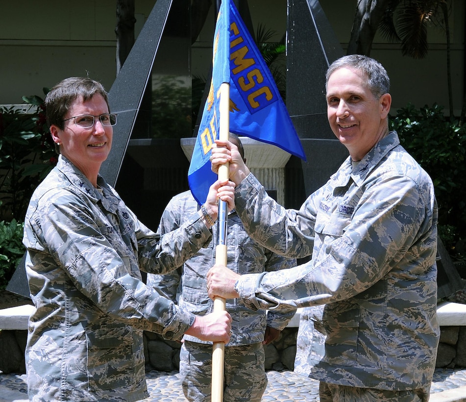 From left, Maj. Gen. Theresa Carter, Air Force Installation and Mission Support Center commander, presents the unit guidon to Col. Mickey Addison as he assumes command of AFIMSC Det. 2 during an activation ceremony, April 9, 2015, at Joint Base Pearl Harbor-Hickam, Hawaii. The Pacific detachment combines and overseas functions from the comptroller, civil engineer, communications, security forces, personnel and special services career fields. (U.S. Air Force photo/Staff Sgt. Amanda Dick/Released)