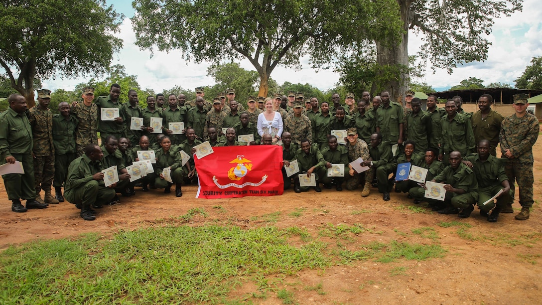 Virginia Blazer, center, the U.S. Deputy Chief of Mission to Tanzania, poses for a photo with Marines and Sailors assigned to a Security Cooperation Team with Special-Purpose Marine Air-Ground Task Force Crisis Response-Africa, and more than 40 Tanzanian park rangers following a graduation ceremony on the Selous Game Reserve in Matambwe, Tanzania, March 27, 2015. The park rangers graduated from counter illicit-trafficking training, which was the first-ever engagement between U.S. Service members and Tanzanian park rangers. The Marines and Sailors taught the park rangers infantry skills in an attempt to help counter illicit-trafficking in the region. 