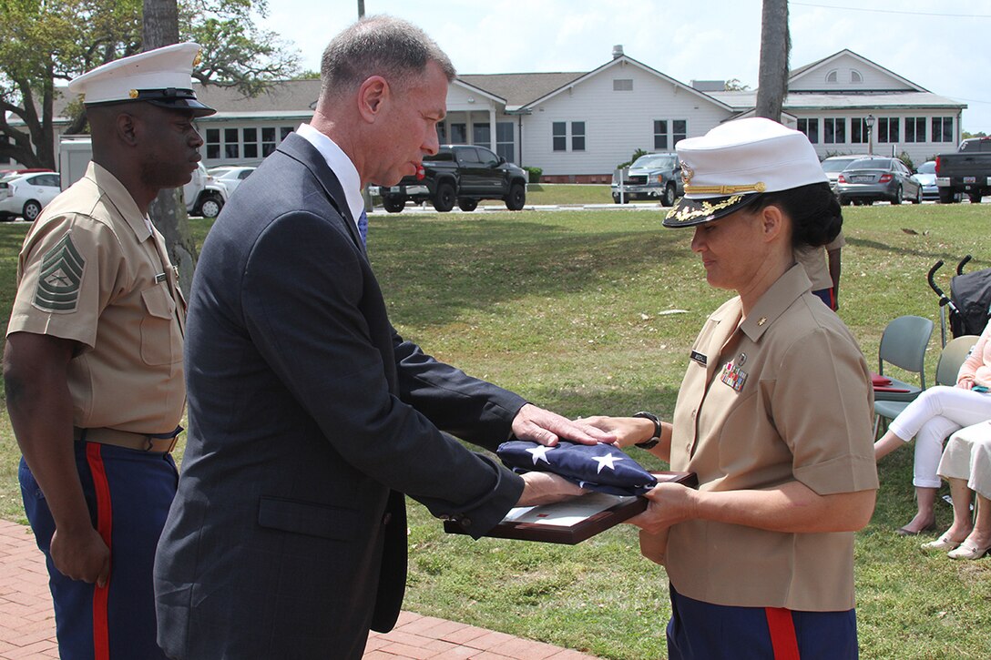 Maj. Mimi C. Seedall, the logistics officer for 6th Marine Corps District, receives Old Glory from retired Col. Scott Blankenship during her retirement ceremony at on Marine Corps Recruit Depot Parris Island, S.C., on April 10, 2015. Seedall retired after 20 years of faithful and honorable service. (Official Marine Corps photo by Cpl. John-Paul Imbody)