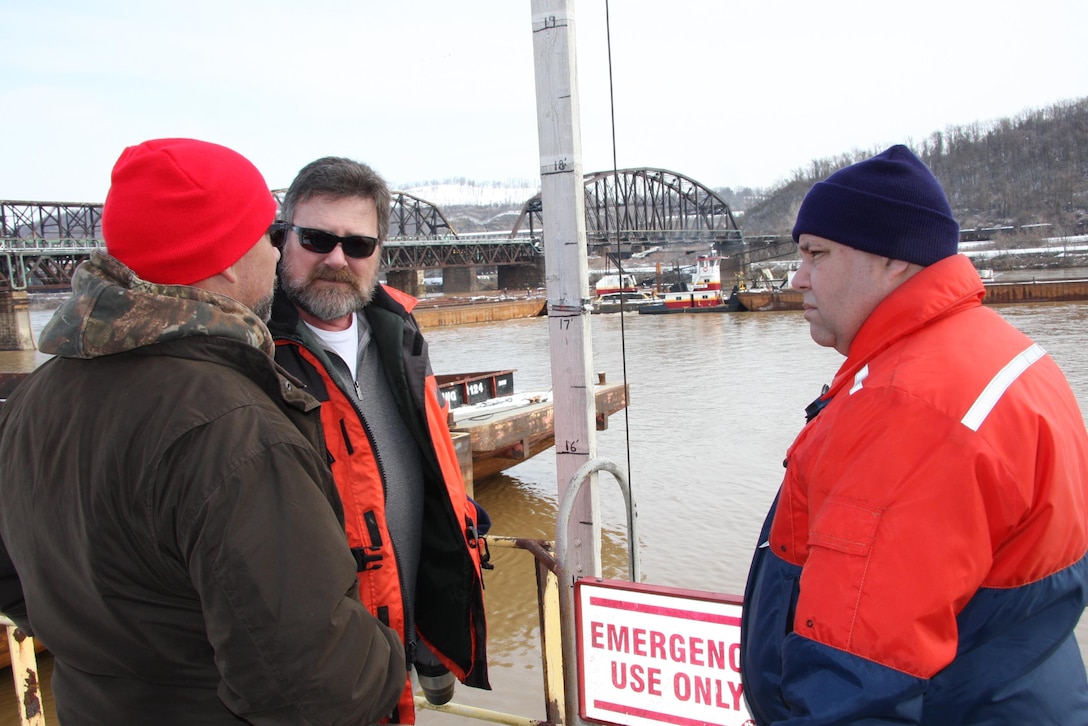 Gary Householder, (center), Mon River operations supervisor, and Mark Ivanisin, (right), Ohio River operations supervisor, speak with an unidentified man during barge recovery operations. 