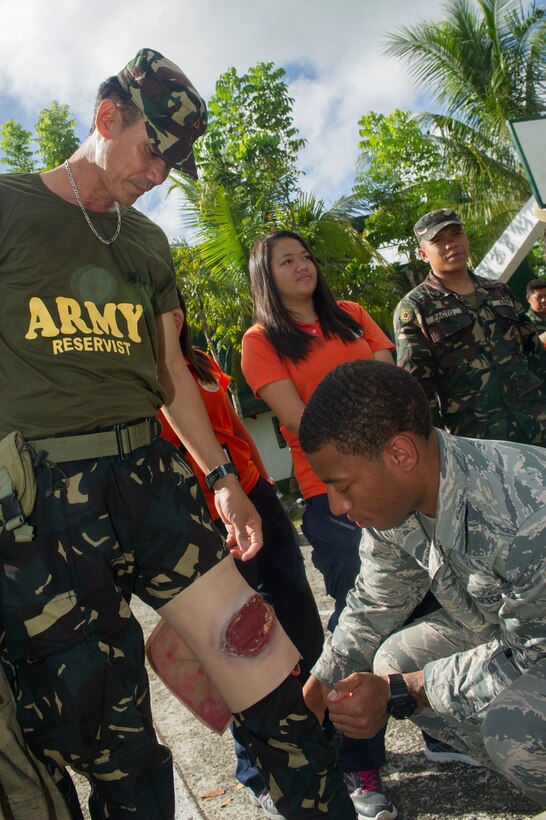 U.S. Air Force Staff Sgt. Justin Stinson, right, assigned to the 15th Medical Operations Squadron, places a simulated wound on the leg of Armed Forces of the Philippines Army Sgt. Danilo Deocampo, assigned to the 6th Regional Defense Group, in preparation for a simulated mass casualty exercise in Jamindan, Philippines, during Balikatan 2015, April 9. The exercise was part of a cooperative health engagement, train-the-trainer first responder course at the headquarters of the AFP’s 3rd Infantry Division, which was attended by AFP Soldiers and civilian personnel from the Capiz Emergency Response Team. Balikatan, which means “shoulder to shoulder” in Filipino, is an annual bilateral training exercise aimed at improving the ability of Philippine and U.S. military forces to work together during planning, contingency, humanitarian assistance and disaster relief operations. 