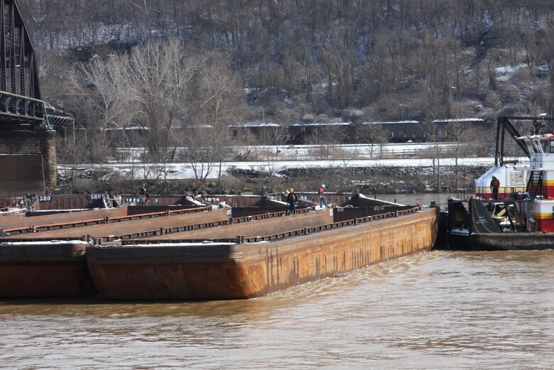 River salvage crews work to free barges lodged against a railroad bridge upstream of Braddock locks and dam on the Mon River.  
