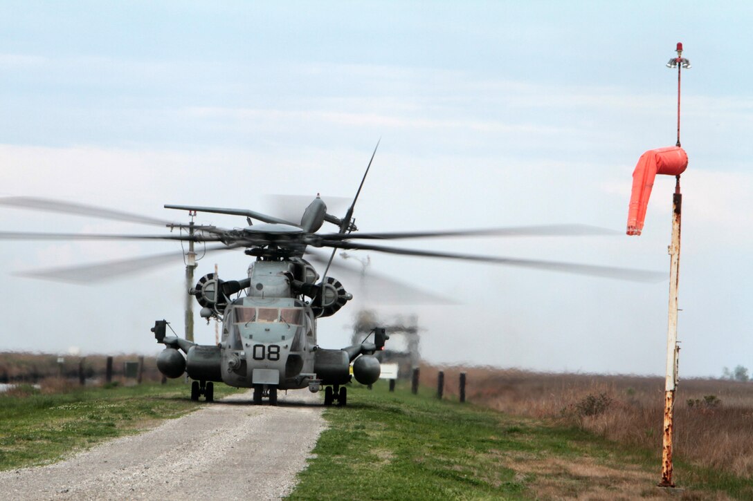 A CH-53E Super Stallion belonging to Marine Heavy Helicopter Squadron 461 sits on a dirt road at Bombing Target 11 on Piney Island, N.C., April 8, 2015.
The aircraft was part of an aerial tour of Marine Corps Air Station Cherry Point's outlying training facilities for members of the Civilian Military Community Council and Joint Land Use Study hosted by the air station. Air station leaders meet periodically with members of the CMCC and JLUS to strengthen ties between Cherry Point and surrounding communities. 
Pilots from Cherry Point and across 2nd Marine Aircraft Wing frequently train at BT-11 to prepare for expeditionary operations, sea-based force projection and aviation support of the Marine Air-Ground Task Force.