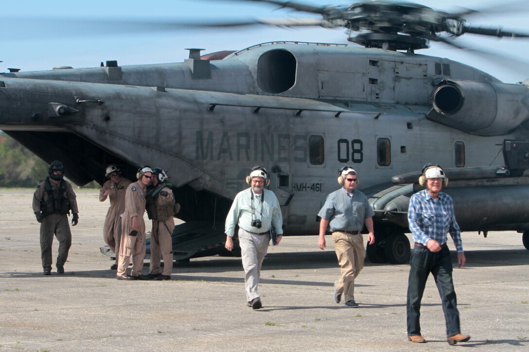 Members of the Civilian Military Community Council and Joint Land Use Study exit the rear of a CH-53E Super Stallion at Outlying Field Atlantic during an aerial tour of Marine Corps Air Station Cherry Point's outlying training facilities, April 8, 2015. 
Air station leaders meet periodically with members of the CMCC and Joint Land Use Study to strengthen ties between Cherry Point and surrounding communities. 
Pilots from Cherry Point and across 2nd Marine Aircraft Wing frequently train at OLF Atlantic to prepare for expeditionary operations, sea-based force projection and aviation support of the Marine Air-Ground Task Force.