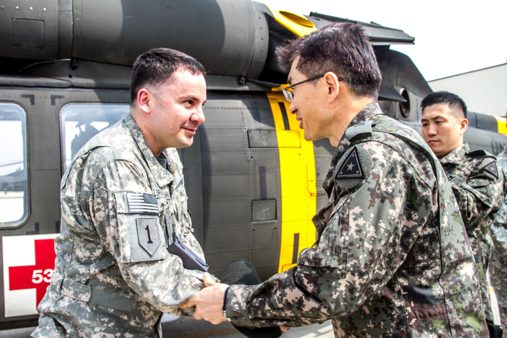 In this file photo, a Soldier from the Company C, 3rd General Support Aviation Battalion shakes hands with Brig. Gen. Ahn, a ROKA surgeon general, April 8, at the Super Hangar on Camp Humphreys in South Korea. Ahn was their to view the 3rd General Support Aviation Battalion's medevac capabilities.