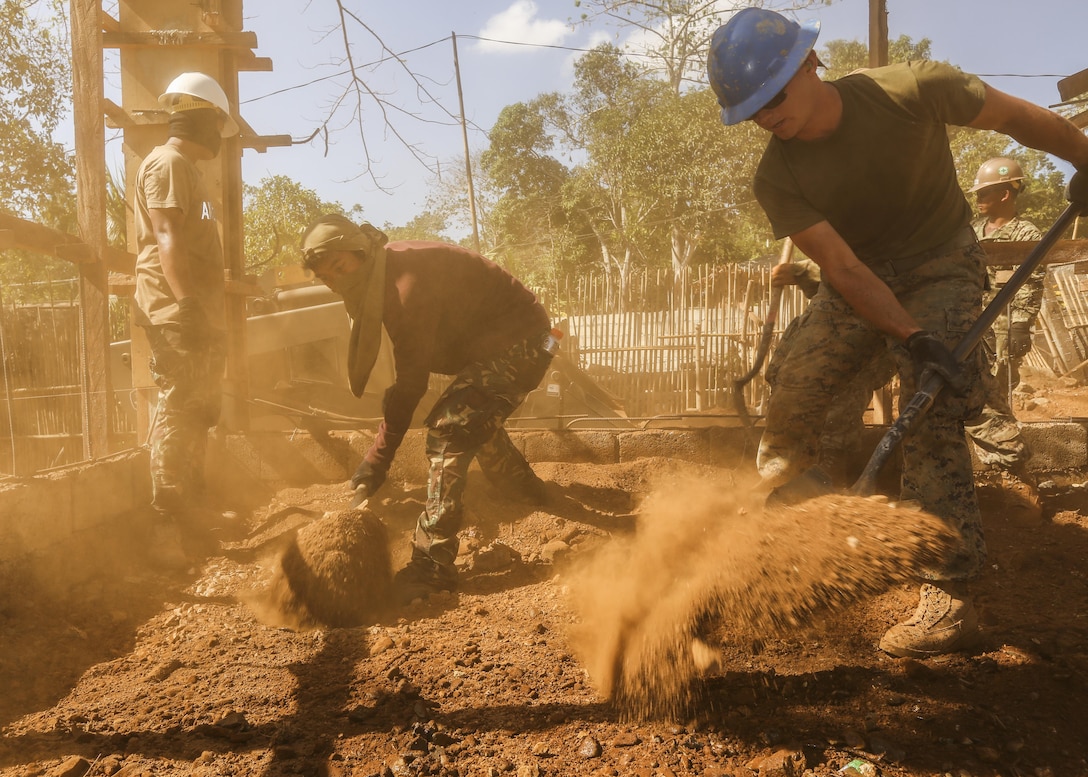 Philippine Airman 2nd Class Bert Agabon, an engineer with Philippines Air Force Engineer Group, and U.S. Marine Lance Cpl. Bradley Trammell, a combat engineer with 9th Engineer Support Battalion, spread dirt for the construction of a new classroom at the Santa Lourdes High School in Puerto Princesa , Philippines, as part of humanitarian civic assistance projects during exercise Balikatan 2015, April 11. The exercise provides an opportunity for Philippine, Australian and U.S. forces to continue strengthening relationships and work together.
