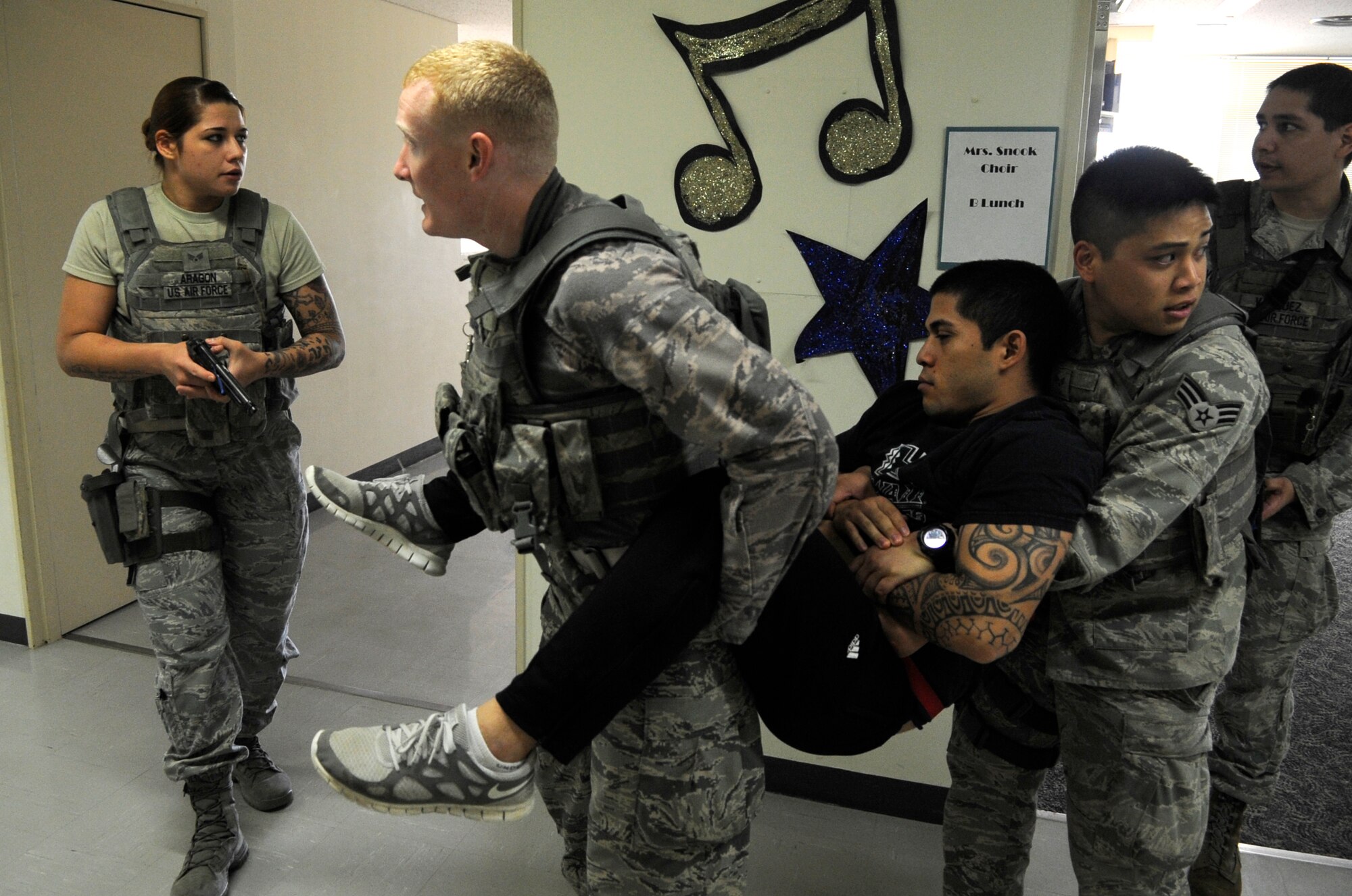 U.S. Air Force 18th Security Forces Squadron response force members carry a simulated casualty to a safe location during a Pacific Air Forces High Risk Response Training course at Kadena Air Base, Japan, April 9, 2015. Role players helped to test the 18th Security Forces Squadron newly learned skills taught during a five day course. (U.S. Air Force photo by Staff Sgt. Marcus Morris)