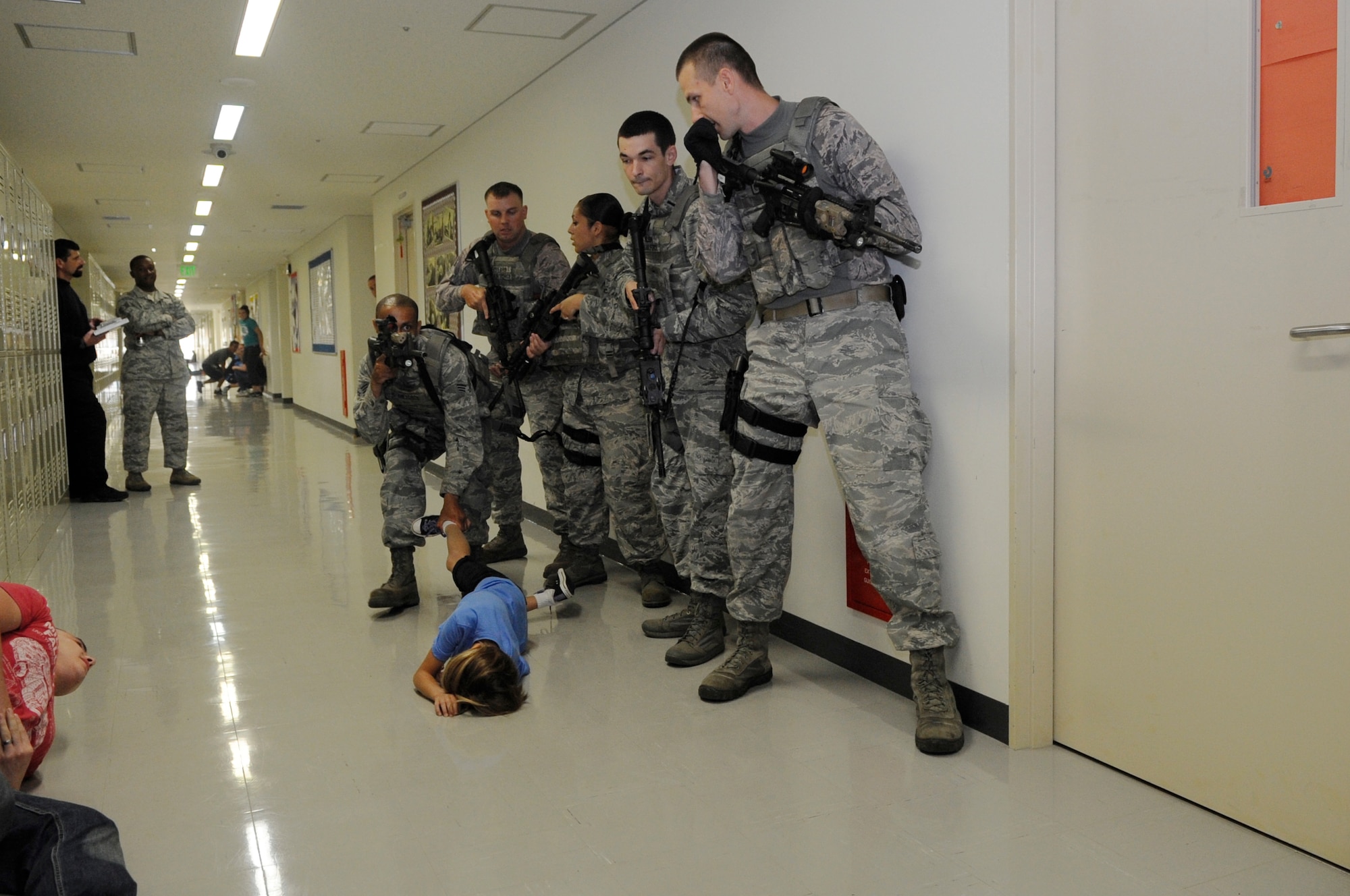 A team of 18th Security Forces Squadron response force members clear the hallway of people in Ryukyu Middle School for an active-shooter scenario during a Pacific Air Forces High Risk Response training course at Kadena Air Base, Japan, April 9, 2015. During this five-day course, participants were taught to swiftly eliminate active shooters and other high-risk threats. (U.S. Air Force photo by Staff Sgt. Marcus Morris)