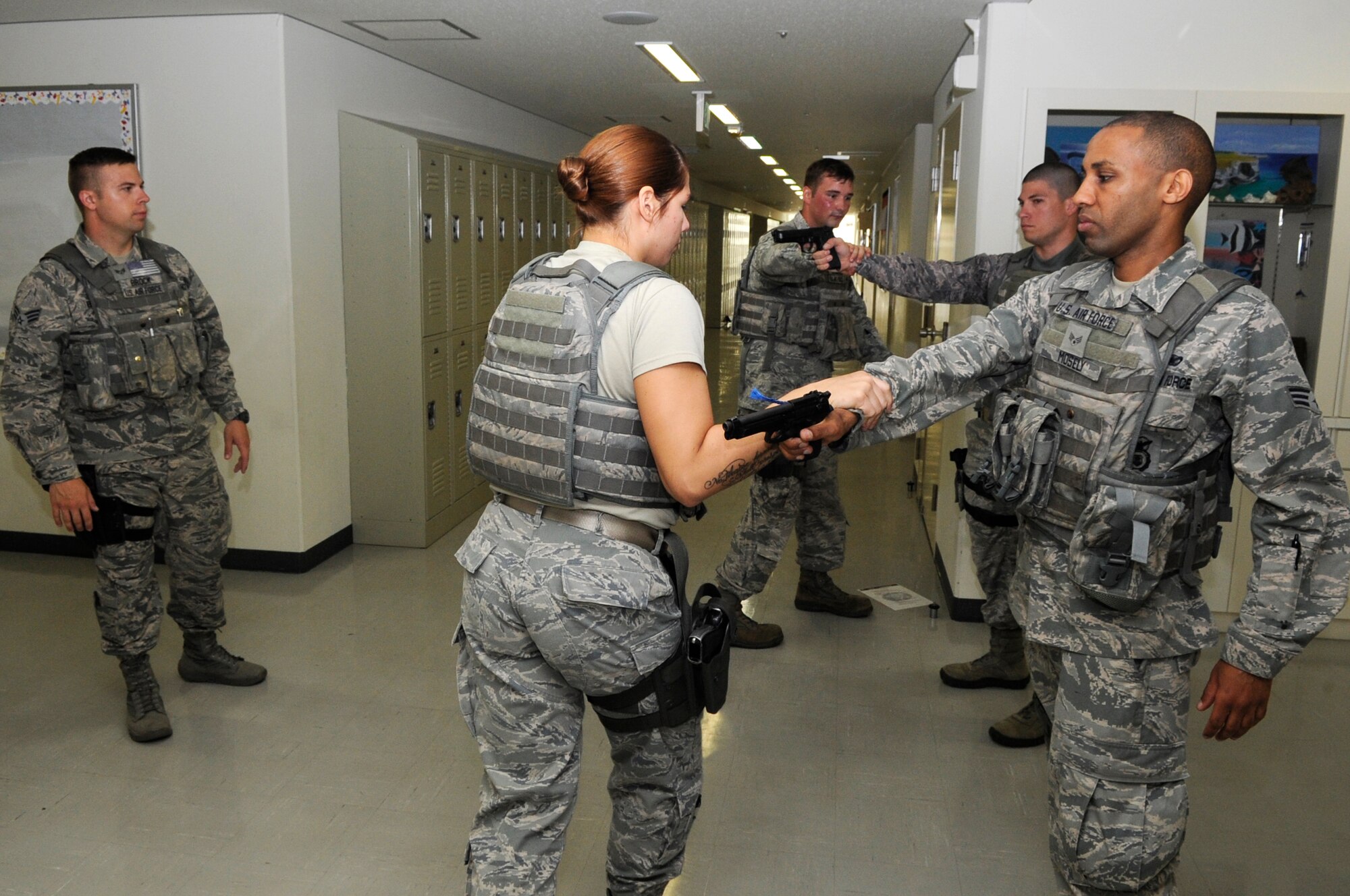 U.S. Air Force Senior Airman Tyler Brock, 18th Security Forces Squadron response force member, oversees response force members practicing defensive techniques and weapon manipulation techniques during a Pacific Air Forces High Risk Response Training at Kadena Air Base, Japan, April 9, 2015. The members took turns leading teams in high-tempo, high-risk scenarios to better prepare them for potential real-world situations. (U.S. Air Force photo by Staff Sgt. Marcus Morris)