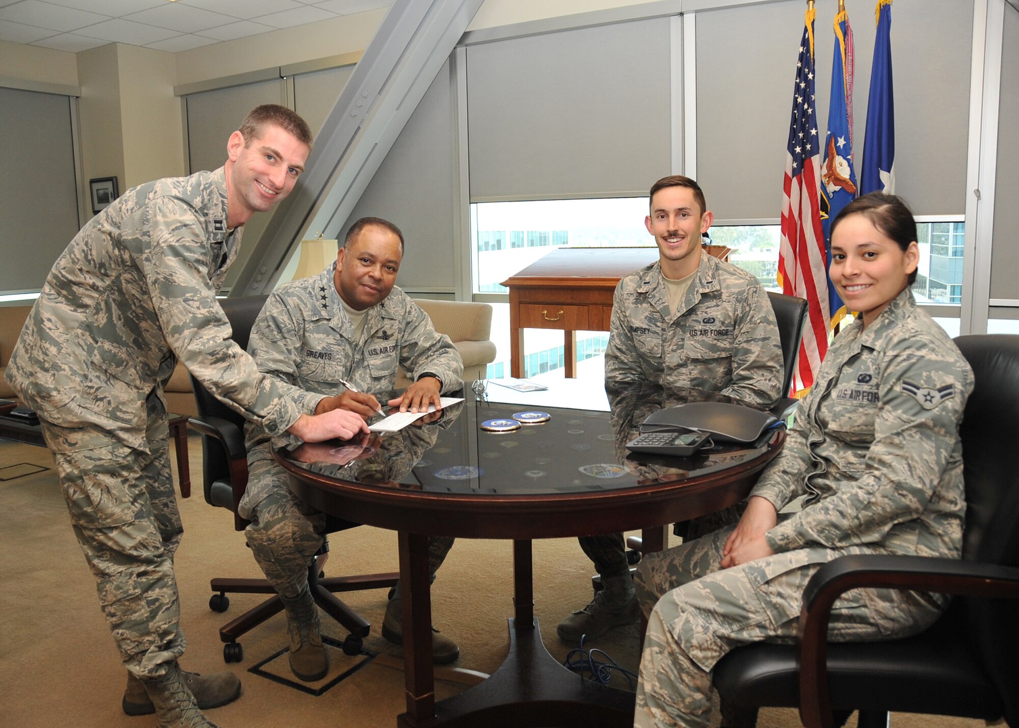 Lt. Gen. Sam Greaves, SMC commander, signs his AFAF pledge form as Installation Project Officers Capt. Trevor Miller, Lt. Shawn Hempsey and Airman Monica Betancourt look on. This year’s AFAF campaign kicked off March 23. 