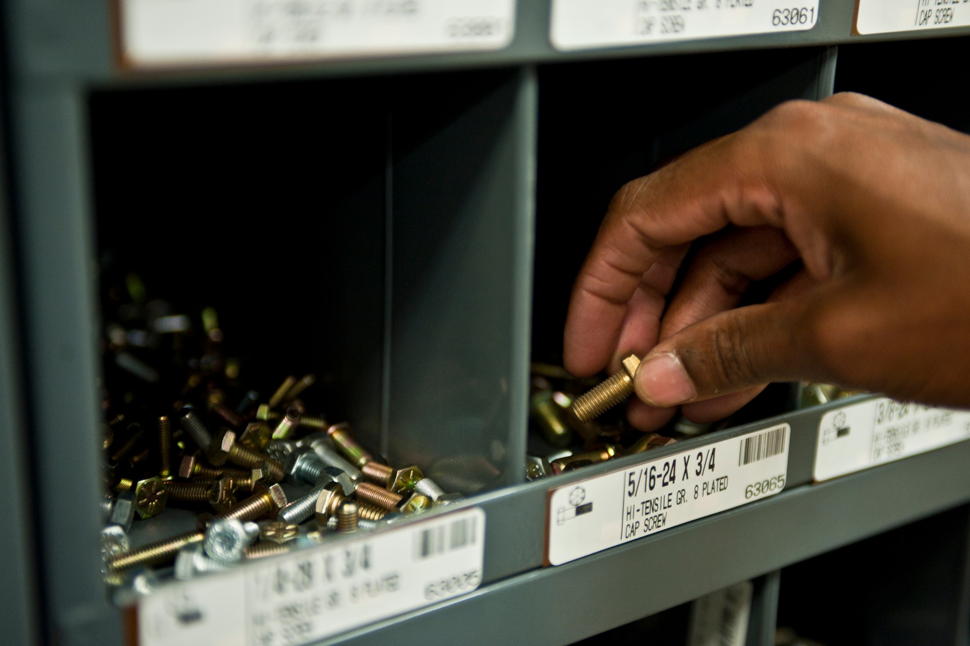 Airman 1st Class Christoffe Kellman, 99th Logistics Readiness Squadron Vehicle Management Flight vehicle management and analysis apprentice, searches for a screw needed for a job at Nellis Air Force Base, Nev., April 7, 2015. The vehicle management flight services vehicles assigned to units on Nellis and Creech AFBs, and the Nevada Test and Training Range in order to help accomplish the installations’ training and operational missions. (U.S. Air Force photo by Airman 1st Class Jake E. Carter)