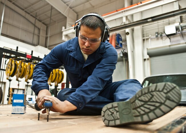 Airman 1st Class Jeremy Alcorta, 99th Logistics Readiness Squadron Vehicle Management Flight general vehicle maintainer, installs new planks in the bed of a truck at Nellis Air Force Base, Nev., April 7, 2015. The vehicle management flight is responsible for repairing and maintaining all government-owned vehicles on base. (U.S. Air Force photo by Airman 1st Class Jake E. Carter)