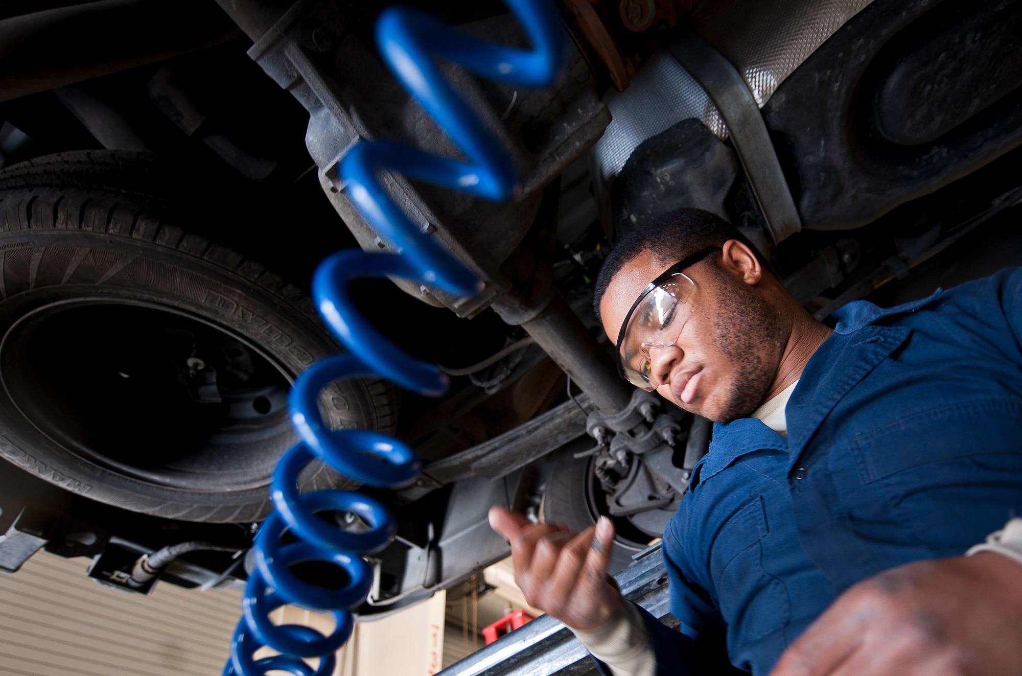 Senior Airman Keeshond White, 99th Logistics Readiness Squadron Vehicle Management Flight general vehicle maintainer, looks at his finger after checking for a fluid leak at Nellis Air Force Base, Nev., April 7, 2015. White and other members of the vehicle management flight maintain and manage Air Combat Command’s largest vehicle fleet. (U.S. Air Force photo by Staff Sgt. Siuta B. Ika)