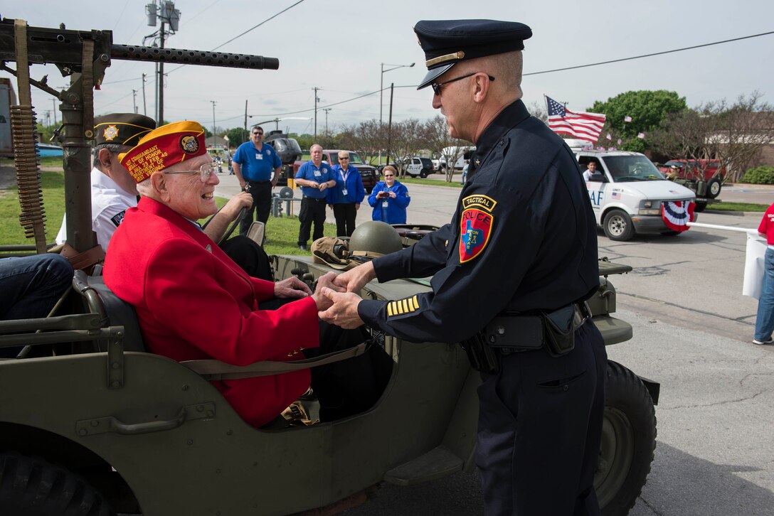 A Cook County police officer shakes Hershel “Woody” Williams hand after the Gainesville, Texas, Medal of Honor Parade, April 11, 2015. Sixteen Medal of Honor recipients participated in the parade and were escorted by Airmen, Soldiers and Sailors from Sheppard Air Force Base, Texas. (U.S. Air Force photo by Senior Airman Kyle Gese/Released)