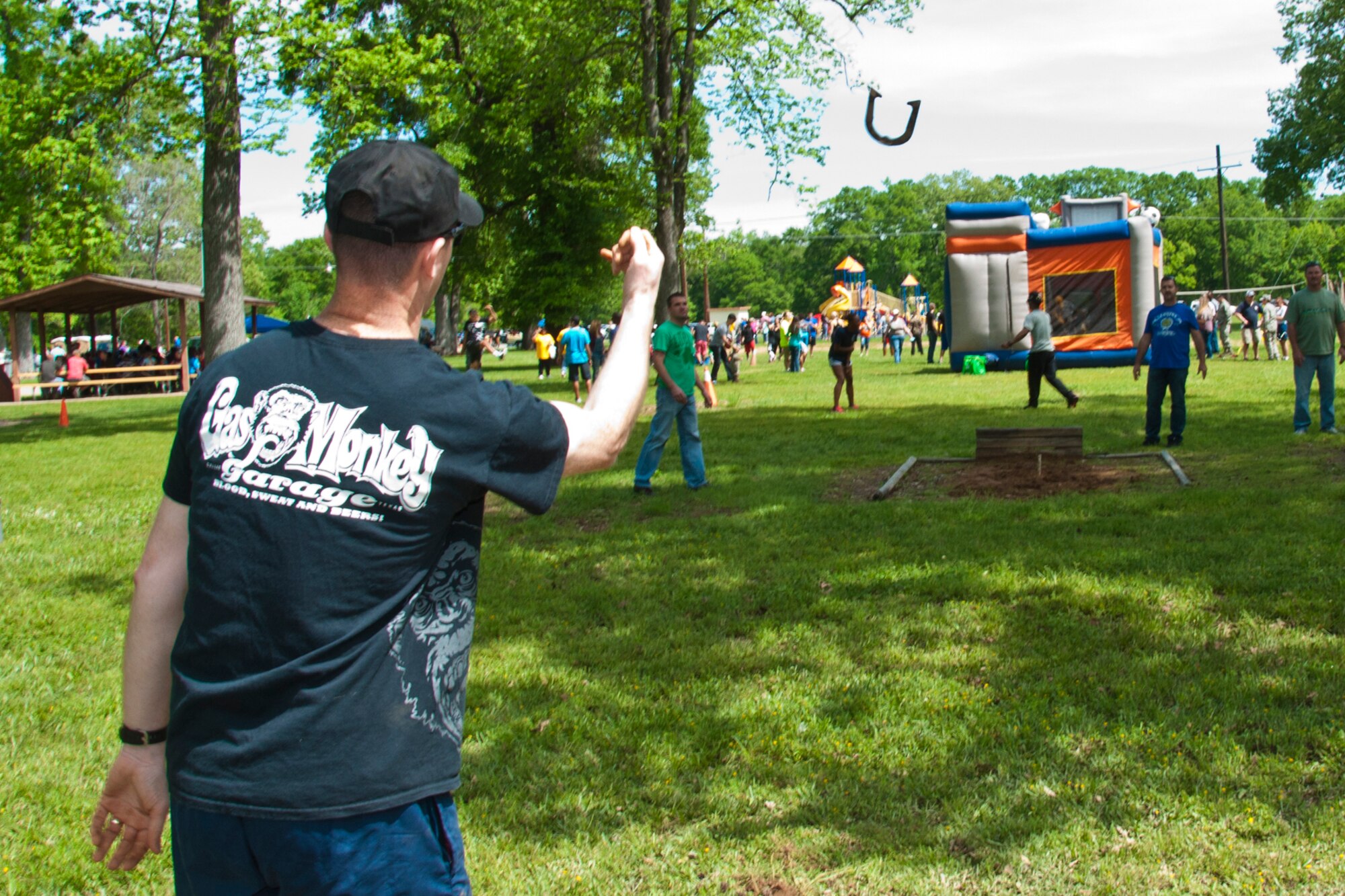 A horseshoe hurtles toward its target during 307th Bomb Wing Family Day activities at Barksdale Air Force Base, La., April 11, 2015.  The friendly competition was one of many that entertained Airmen and their family members throughout the day.   Other competitions included a 5K race, dodgeball, volleyball, a scavenger hunt, and track relays.  Col. Bruce Cox, 307th BW commander, awarded the top three finishers in each event with an Olympic style medal.  (U.S. Air Force photo by Tech. Sgt. Ted Daigle/Released)