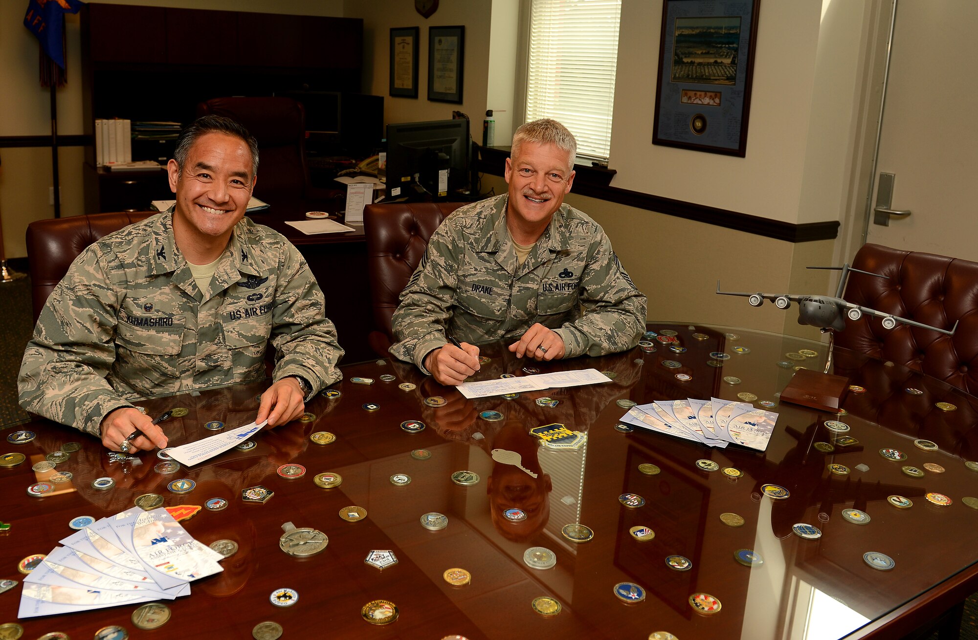 Col. David Kumashiro, (left) 62nd Airlift Wing commander, and Chief Master Sergeant Gordon Drake, 62nd AW command chief, fill out their Air Force Assistance Fund forms April 10, 2015 at Joint Base Lewis-McChord, Wash. AFAF is an annual fund raising campaign that provides assistance to Airmen and their families. The campaign runs from March 23 to May 1 at Joint Base Lewis-McChord and the goal for 2015 is to raise more than $63,000.  For more information on AFAF or to donate contact your unit representative. (U.S. Air Force photo/ Staff Sgt. Tim Chacon)