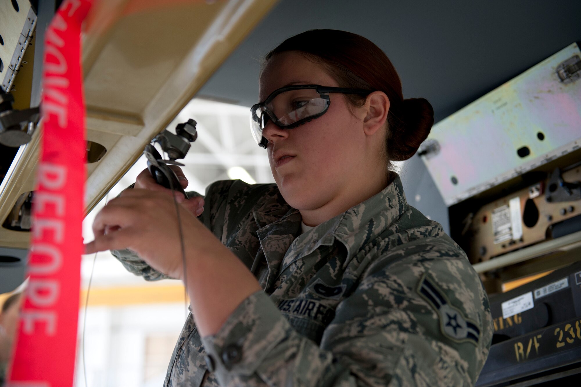 Airman 1st Class Trisha Magruder, 49th Aircraft Maintenance Squadron, a member of weapon load crew 50, preps an MQ-9 Reaper for weapons loading during a weapons load competition at Holloman Air Force Base, N.M. April 10, 2015. The MQ-9 load crew participated in the competition to have their skills evaluated. For the competition, points are awarded for weapons-loading, toolkit inspection, and uniform inspection. (U.S. Air Force photo by Staff Sgt. E’Lysia A. Wray/Released)