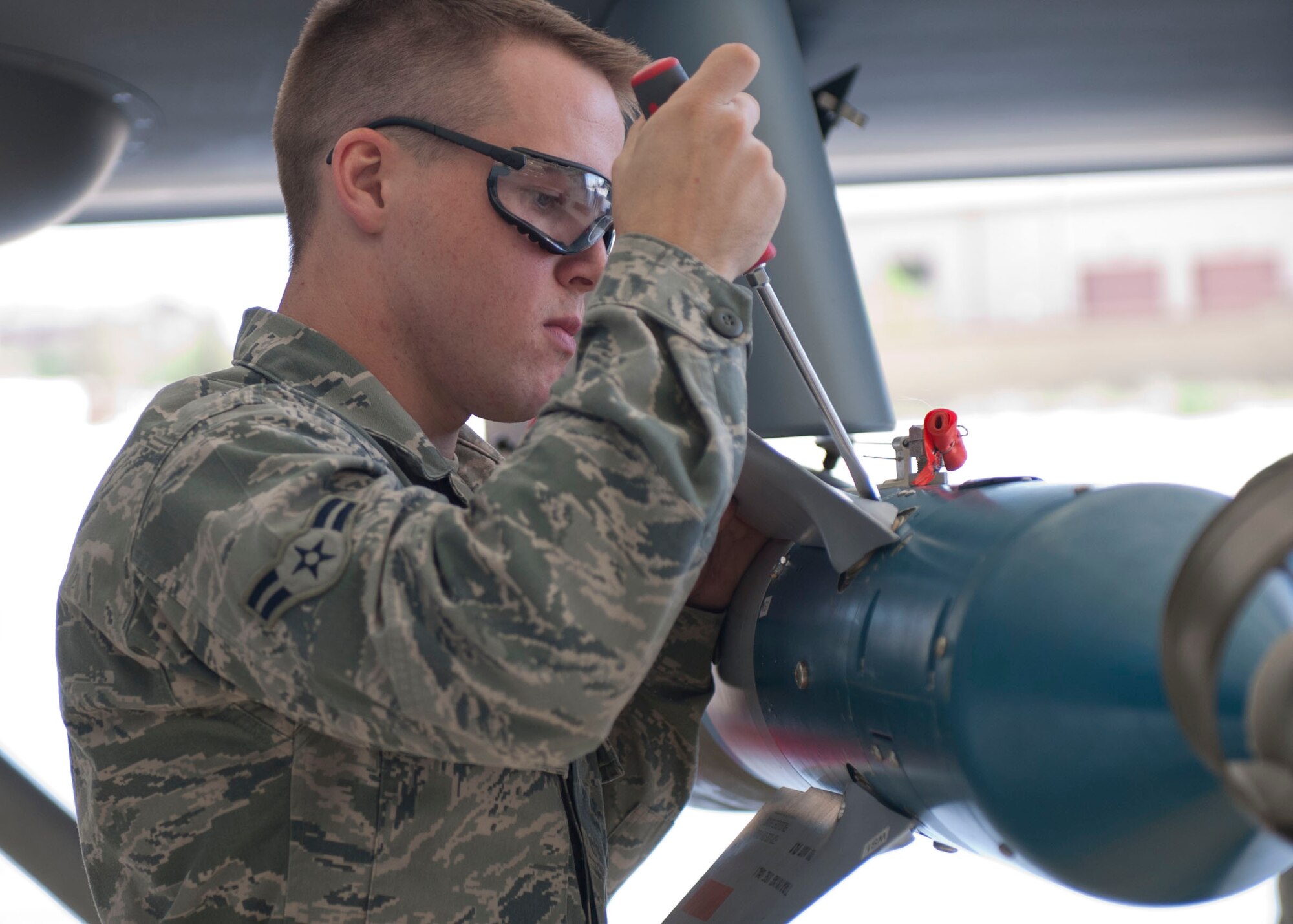 Airman 1st Class Noah Belt, 49th Aircraft Maintenance Squadron, a member of weapon load crew 50, secures an GBU-12 Paveway II during a weapons load competition at Holloman Air Force Base, N.M. April 10, 2015. A GBU-12 Paveway II is a laser-guided bomb based on MK 82 500-pound general purpose bomb. For the competition, points are awarded for weapons-loading, toolkit inspection, and uniform inspection. (U.S. Air Force photo by Staff Sgt. E’Lysia A. Wray/Released)