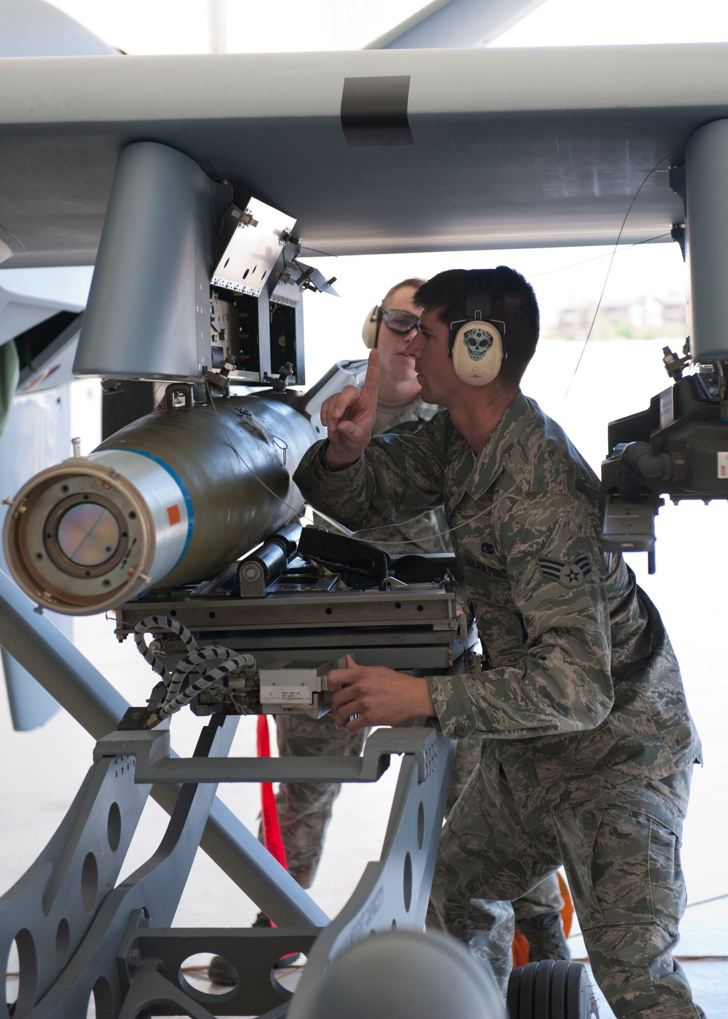 Senior Airman Thomas Lahut, 49th Aircraft Maintenance Squadron, a member of weapon load crew 53, loads a GBU-12 Paveway II during a weapons load competition at Holloman Air Force Base, N.M. April 10, 2015. The MQ-9 load crew participated in the competition to have their skills evaluated. For the competition, points are awarded for weapons-loading, toolkit inspection, and uniform inspection. (U.S. Air Force photo by Staff Sgt. E’Lysia A. Wray/Released)