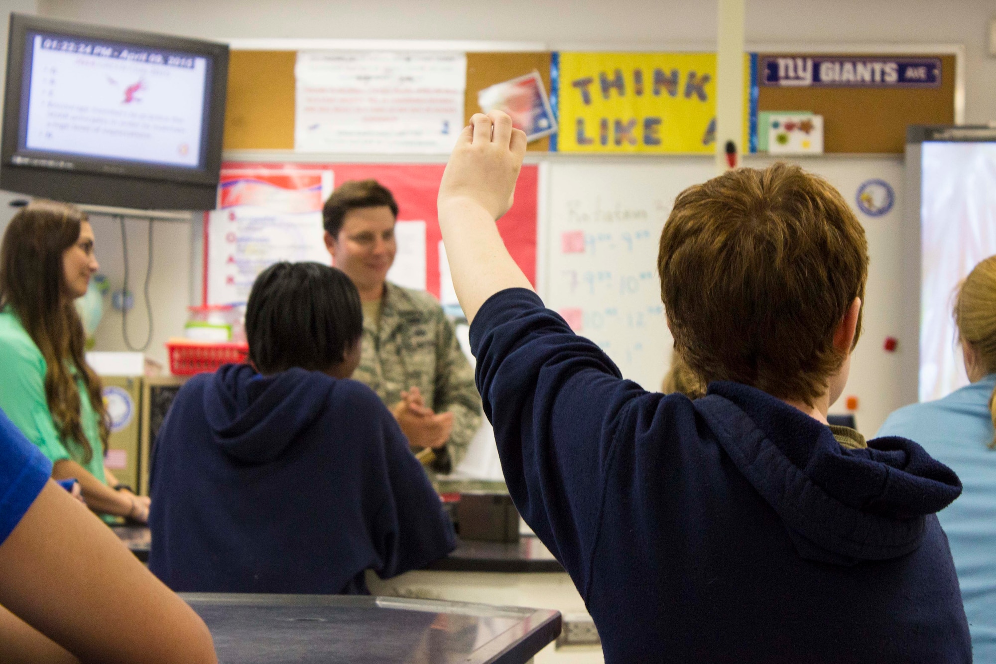 A seventh grader at Everitt Middle School in Panama City, Florida, raises his hand to ask a question during a robotics presentation April 9. Representatives from the Air Force Civil Engineer Center at nearby Tyndall Air Force Base and the 823rd RED HORSE Squadron at the base’s Silver Flag Exercise Site taught students about working in a science, technology, engineering and math field for National Robotics Week. (U.S. Air Force photo/ Released)
