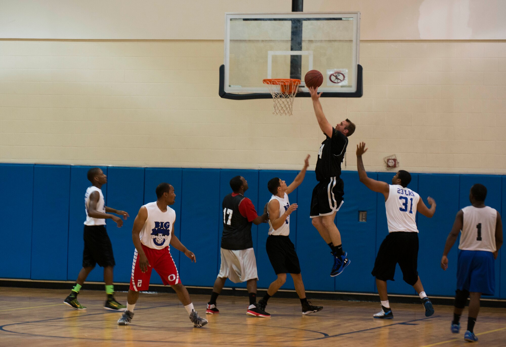 U.S. Air Force Airman Kyle Crumpton, 824th Base Defense Squadron fireteam member, attempts a lay-up during Moody Air Force Base’s intramural basketball championship game April 8, 2015, at the Freedom 1 Fitness Center. Even though double teamed, Crumpton managed to make the lay-up and lead the team to win the first game of double elimination. (U.S. Air Force photo by Airman 1st Class Dillian Bamman/Released)