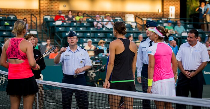 Col. Jeffrey DeVore, Joint Base Charleston commander flips a coin to begin the Family Circle Cup Tennis Tournament on Military Appreciation Night April 9, 2015, at the Family Circle Cup stadium on Daniel Island, S.C. Along with DeVore are representatives from the Family Circle Cup and several professional tennis players from around the world. (U.S. Air Force photo/Airman 1st Class Clayton Cupit)