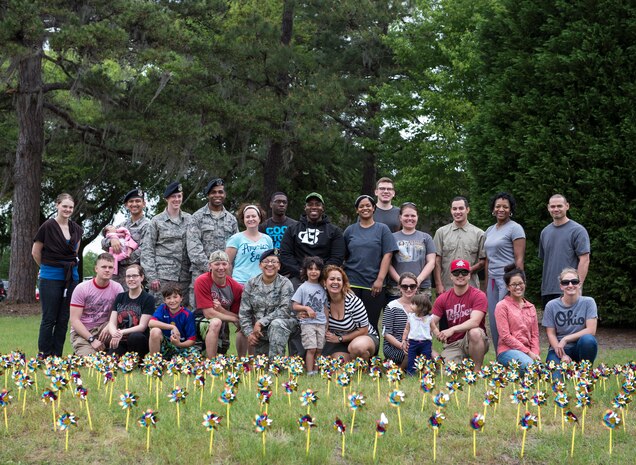 Airmen, civilians and family members from the Holocaust Remembrance Committee pose for a group photo behind 1,000 pinwheels April 12, 2015 at Joint Base Charleston, S.C. Holocaust Remembrance Day is Thursday April 16, 2015 and the pinwheels represent the multicultural victims of the Holocaust. The pinwheels will be displayed as a memorial for a week on Hill Blvd. (U.S. Air Force photo/Senior Airman Jared Trimarchi)