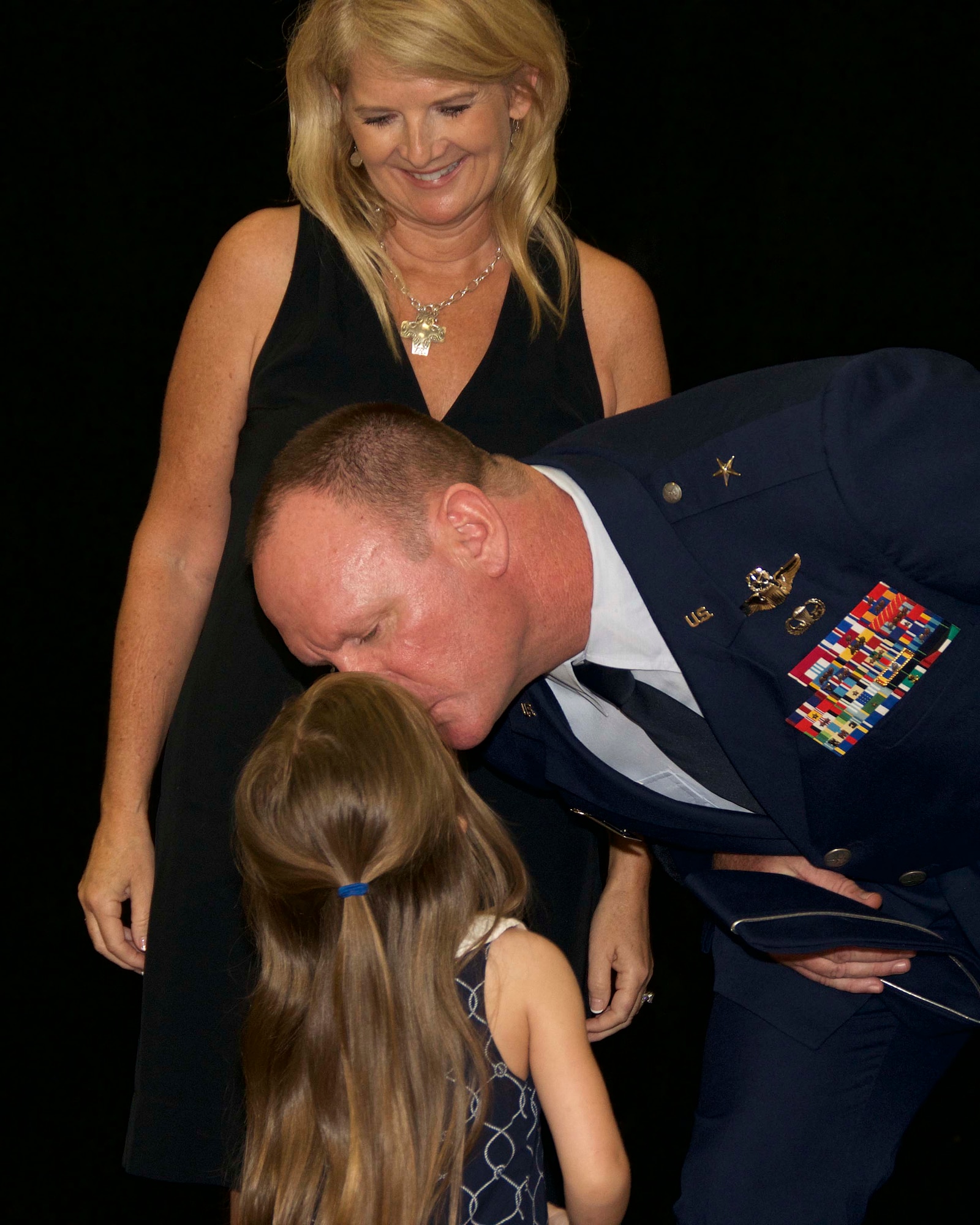Brig. Gen. Christian G. Funk kisses his granddaughter, Charlotte, after she helped pin on his new rank along with his wife, Lori during the promotion ceremony. During the ceremony, Funk, the 482nd Fighter Wing commander was officially promoted to the rank of brigadier general at Homestead Air Reserve Base, Fla., April 11. (U.S. Air Force photo by Staff Sgt. Jaimi L. Upthegrove)