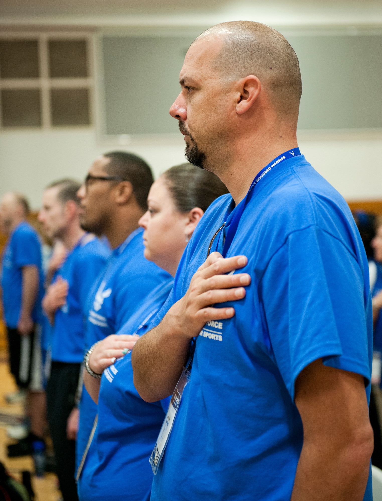 Athletes and mentors listen to the National Anthem during the opening ceremony of the Air Force introductory adaptive sports and rehabilitation camp at Eglin Air Force Base, Fla., April 13. The DOD’s military adaptive sports program enhances warrior recovery by engaging wounded, ill and injured service members in ongoing, daily adaptive activities, based on their interest and ability. This is the first event of the type to be held at Eglin. (U.S. Air Force photo/Samuel King Jr.)
