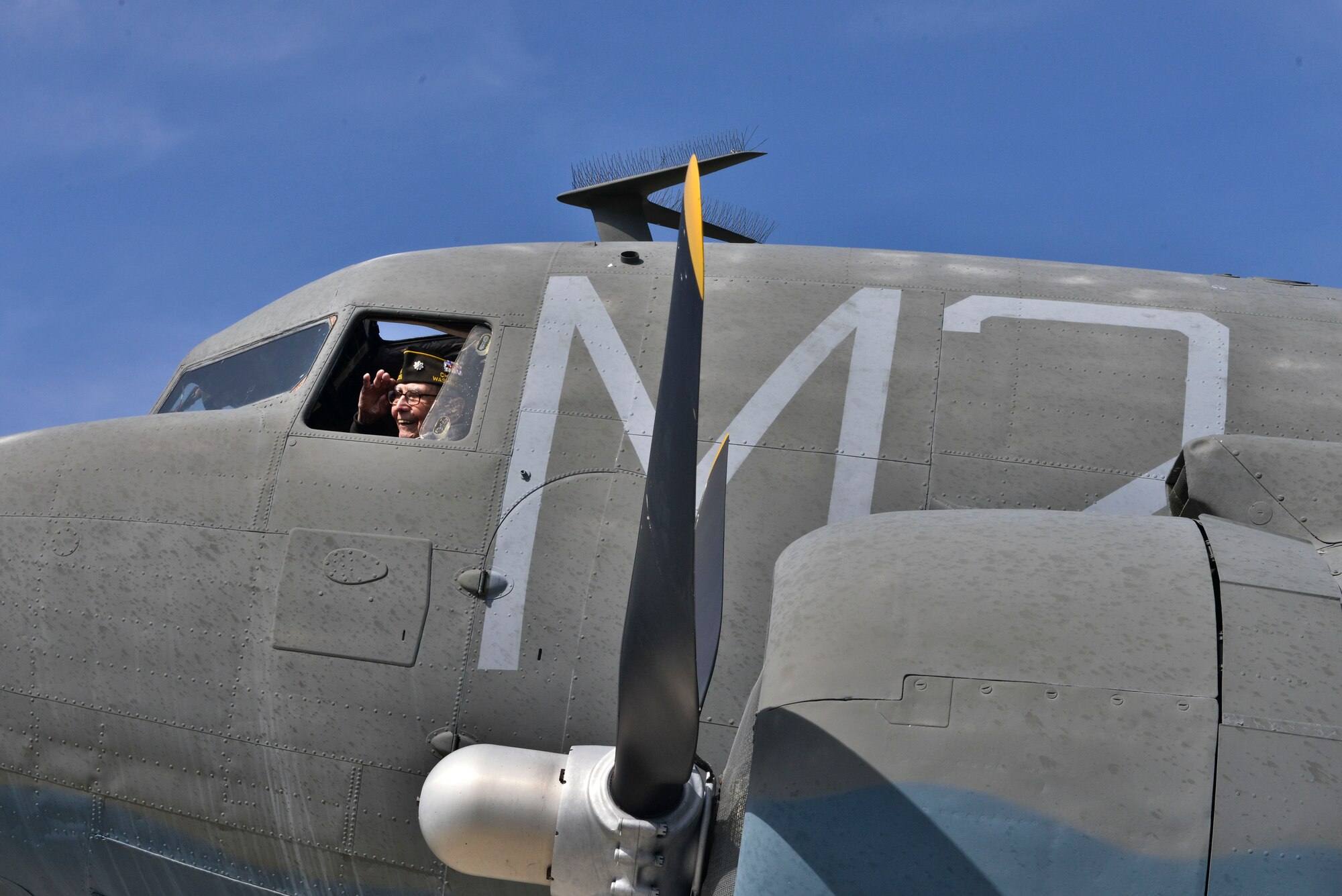Retired U.S. Air Force Lt. Col. Alston Daniels salutes out of the window of a C-47D Skytrain on static display at Fairchild AFB, Wash. April 7, 2015. Daniels flew the C-47 during World War II and logged nearly 2,000 hours in the aircraft. (U.S. Air Force photo/Staff Sgt. Alex Montes)